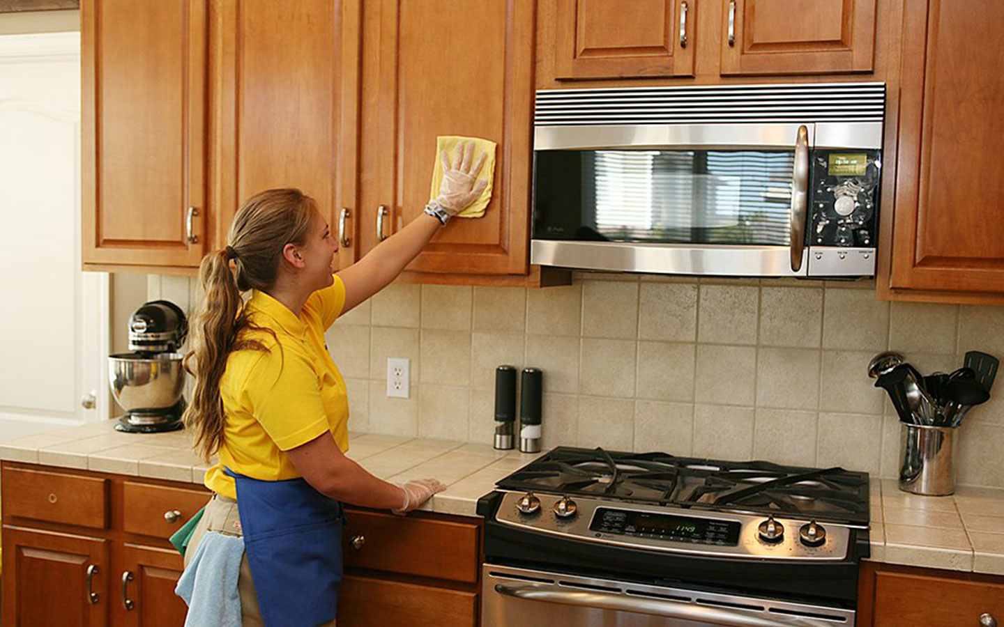 Woman cleaning kitchen cabinets